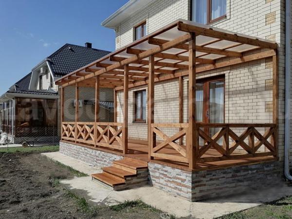 Деревянная терраса с полупрозрачной крышей и высоким цоколем